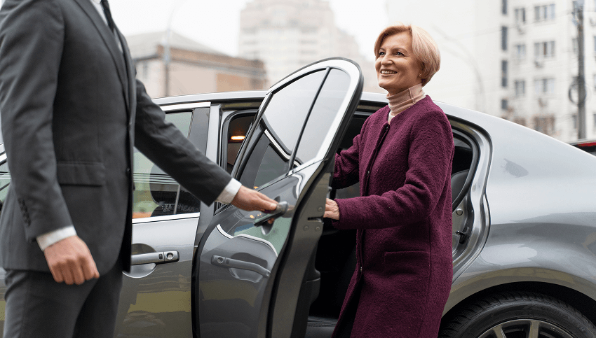 Limousine service representative helping client with luggage